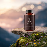 Wellness Essentials bottle on a mossy mountain ledge above a misty valley at sunrise