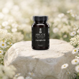 Lactoferrin bottle on a pale limestone rock in a meadow of white chamomile