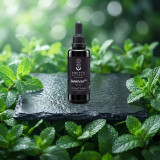 InsuLess dropper bottle on dark wet slate among fresh, dewy mint leaves